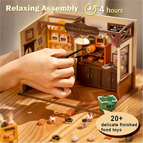 Hand assembling miniature bakery diorama with food toys.