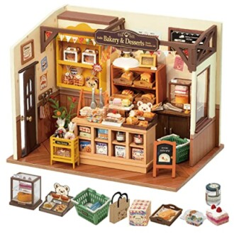 Miniature bakery shop with desserts, teddy bear, and accessories.