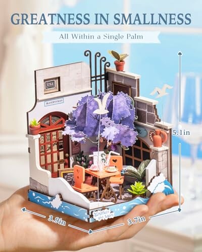 Miniature 3D puzzle of a coffee shop held in a hand, showcasing detailed architecture and decor.