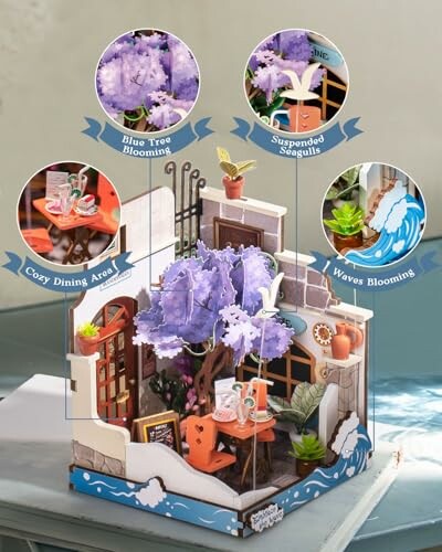Miniature seaside diorama with blooming tree, seagulls, and dining area.