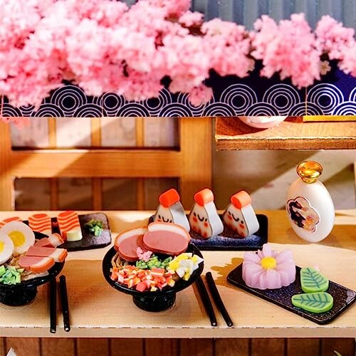 Miniature Japanese food display with sushi, rice balls, and desserts.