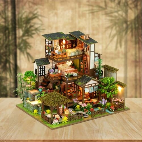 Intricate miniature Japanese house diorama with detailed rooms and garden.