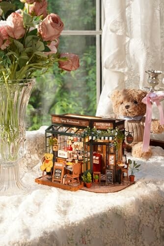 Miniature vintage shop display with teddy bear and flowers.